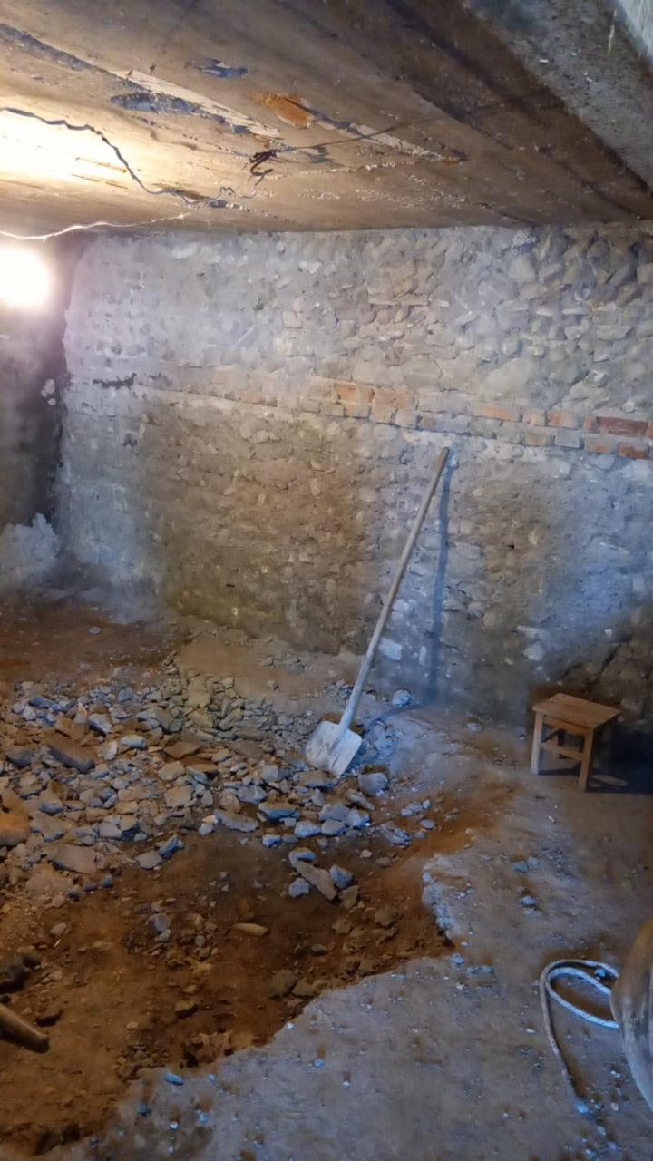 ძველი ქვის კედლების მქონე შიდა სივრცე დემონტაჟისა და გაწმენდის პროცესში
